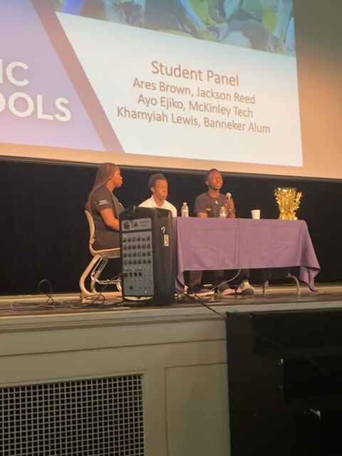 Ayotunde Ejiko speaking on a student voice panel in an auditorium